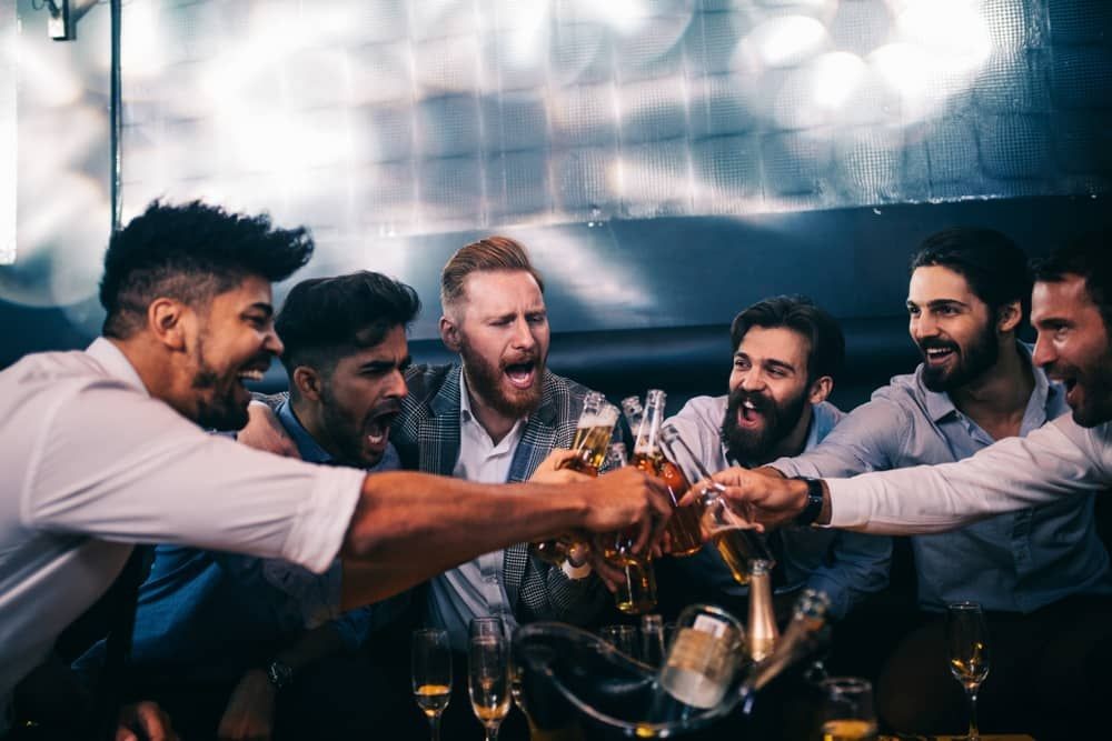 Group of friends enjoying drinks during a Las Vegas strip club crawl, designed for Arizona guests as part of a VIP bachelor party experience.